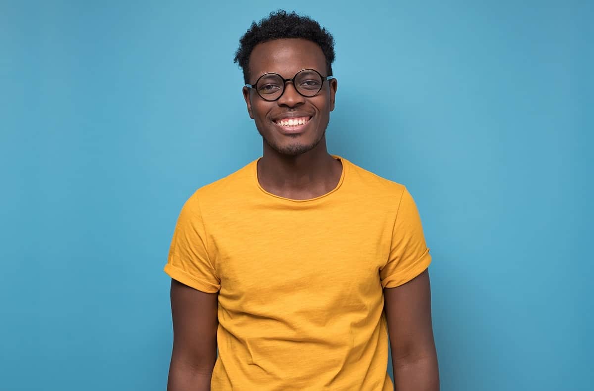 man with bright colored shirt shows off his straight smile thanks to Invisalign