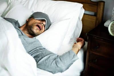 man sleeping and snoring in bed